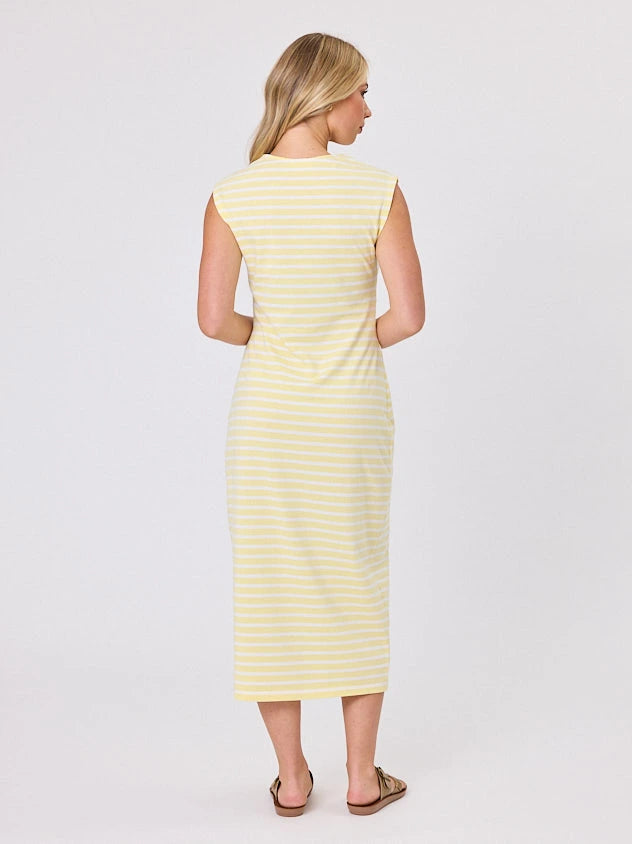 Woman wearing a coastal living inspired yellow striped cotton dress by Navy & Co, standing front-facing in natural light