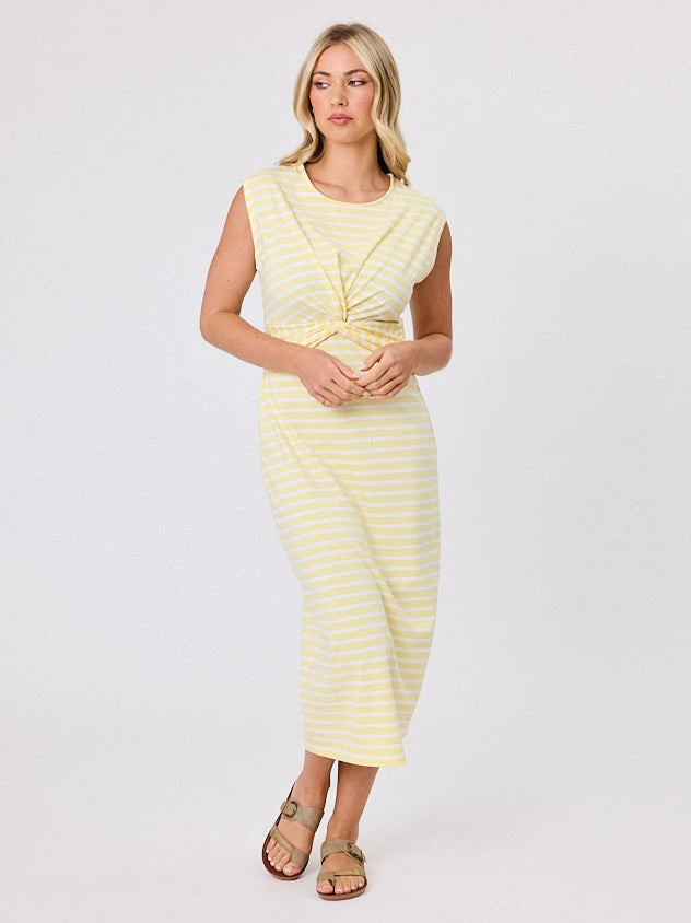 Woman wearing a coastal living inspired yellow striped cotton dress by Navy & Co, standing front-facing in natural light