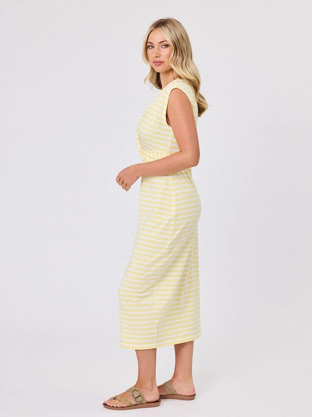 Woman wearing a coastal living inspired yellow striped cotton dress by Navy & Co, standing front-facing in natural light