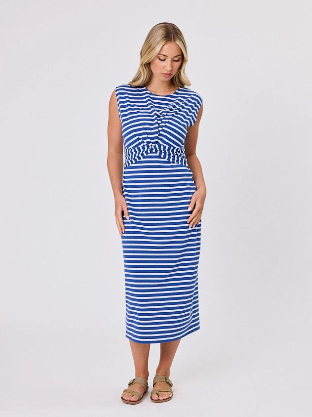 Woman wearing a coastal living inspired ocean blue striped cotton dress by Navy & Co, standing front-facing in natural light