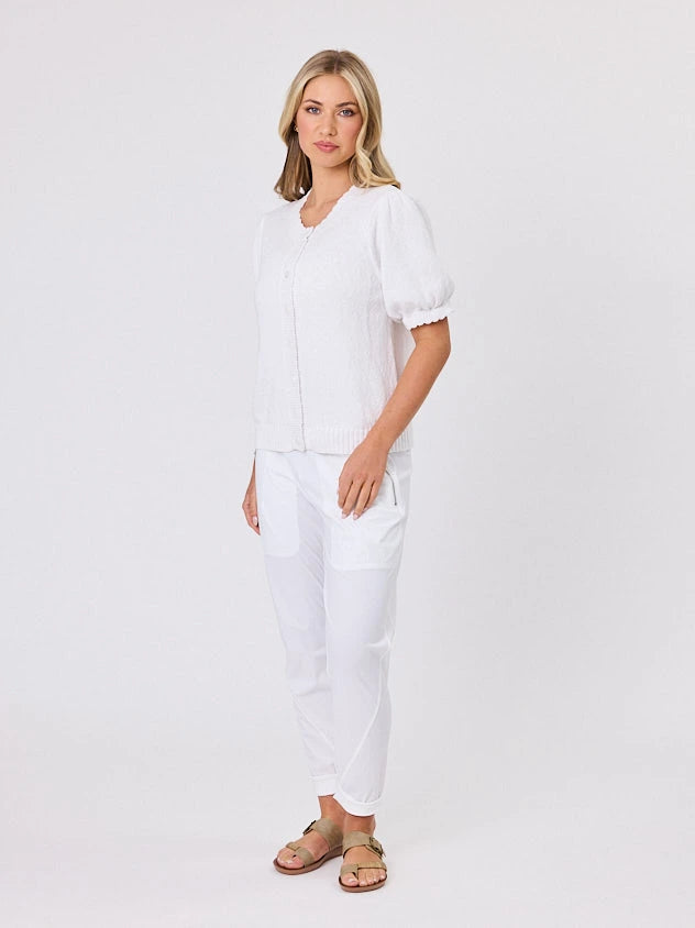 Woman wearing a white lightweight knit cotton cardi top by Navy & Co fashion brand, standing front-facing in natural light