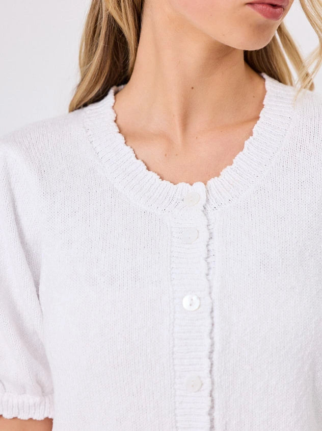 Woman wearing a white lightweight knit cotton cardi top by Navy & Co fashion brand, standing front-facing in natural light