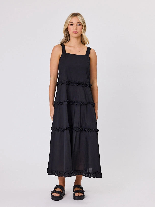 Woman standing front-facing in natural light wearing a black A-line Regalia dress by Navy & Co fashion brand 