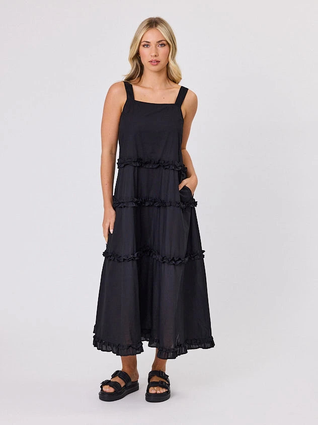 Woman standing front-facing in natural light wearing a black A-line Regalia dress by Navy & Co fashion brand 