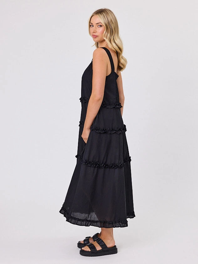 Woman standing front-facing in natural light wearing a black A-line Regalia dress by Navy & Co fashion brand 