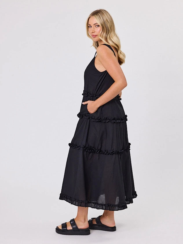 Woman standing front-facing in natural light wearing a black A-line Regalia dress by Navy & Co fashion brand 