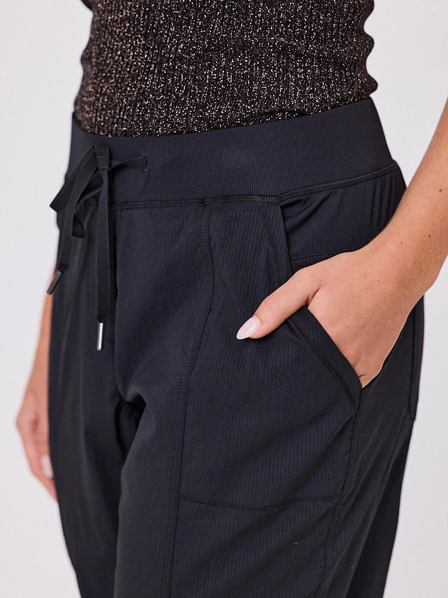 Woman standing front-on in studio light wearing black voyage crew pants, with white stich by Navy & Co nz fashion brand 