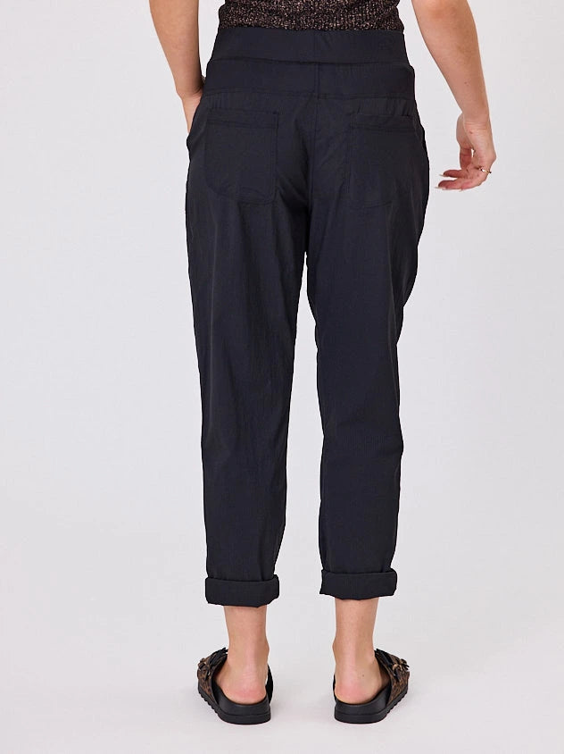 Woman standing front-on in studio light wearing black voyage crew pants, with white stich by Navy & Co nz fashion brand 