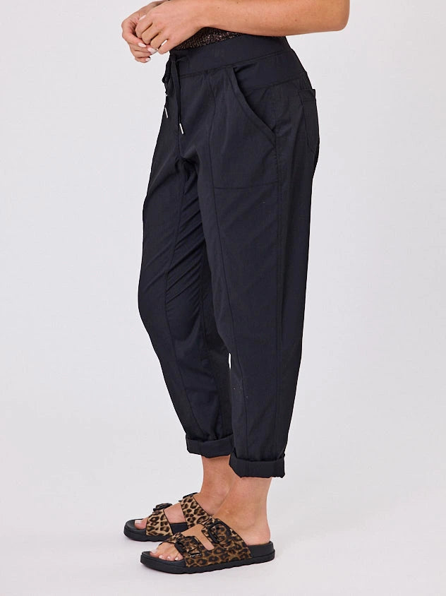 Woman standing front-on in studio light wearing black voyage crew pants, with white stich by Navy & Co nz fashion brand 