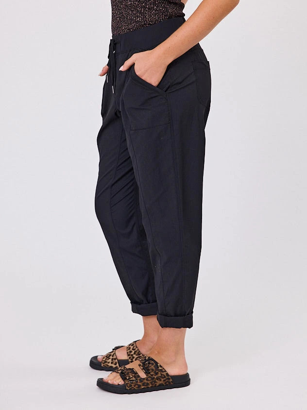 Woman standing front-on in studio light wearing black voyage crew pants, with white stich by Navy & Co nz fashion brand 