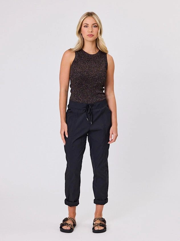 Woman wearing a black sleeveless top and Navy & Co black pants on a white background