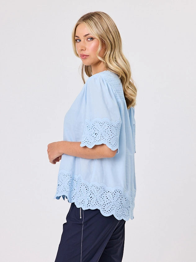 Woman standing front-on in studio light wearing pastel blue cotton top, by Navy & Co nz fashion brand 