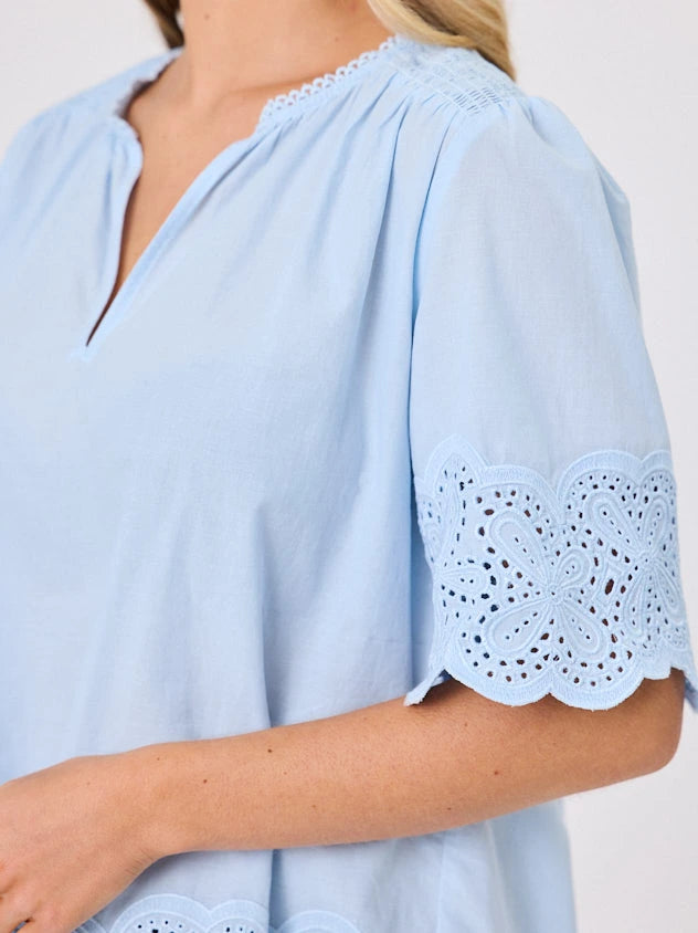 Woman standing front-on in studio light wearing pastel blue cotton top, by Navy & Co nz fashion brand 