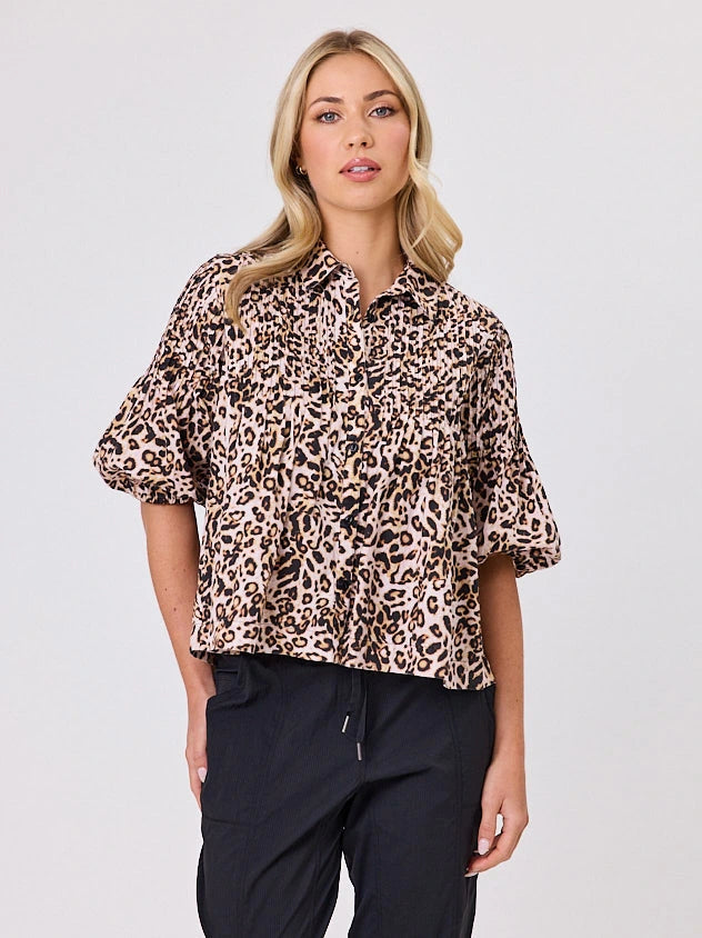 One woman dressed in cotton animal print bubble shirt, by Navy & Co a NZ fashion brand, she is standing front-on in studio light