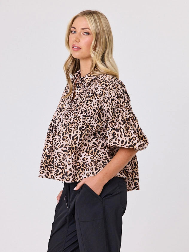 One woman dressed in cotton animal print bubble shirt, by Navy & Co a NZ fashion brand, she is standing front-on in studio light
