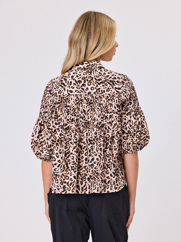 One woman dressed in cotton animal print bubble shirt, by Navy & Co a NZ fashion brand, she is standing front-on in studio light