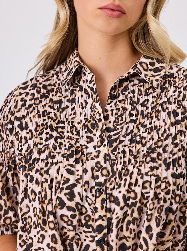 One woman dressed in cotton animal print bubble shirt, by Navy & Co a NZ fashion brand, she is standing front-on in studio light